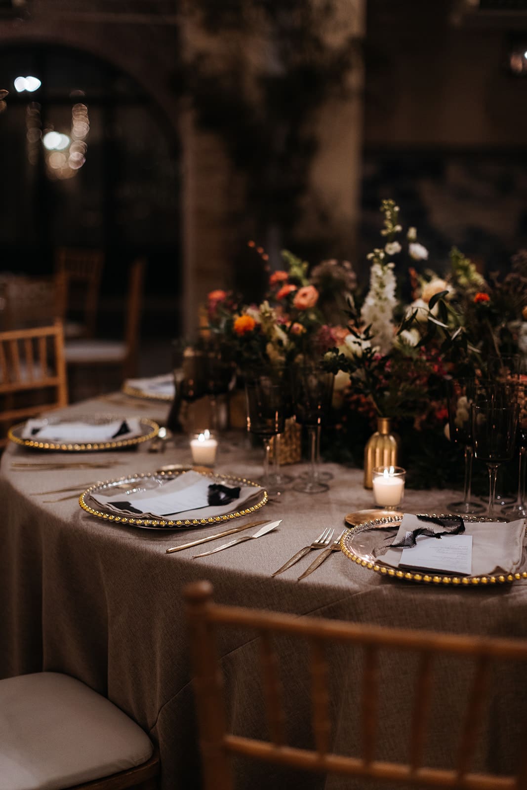 Decoración de mesa nupcial con vajilla dorada y centro floral en una boda española. Creada por wedding planner de Bouclé Weddings.