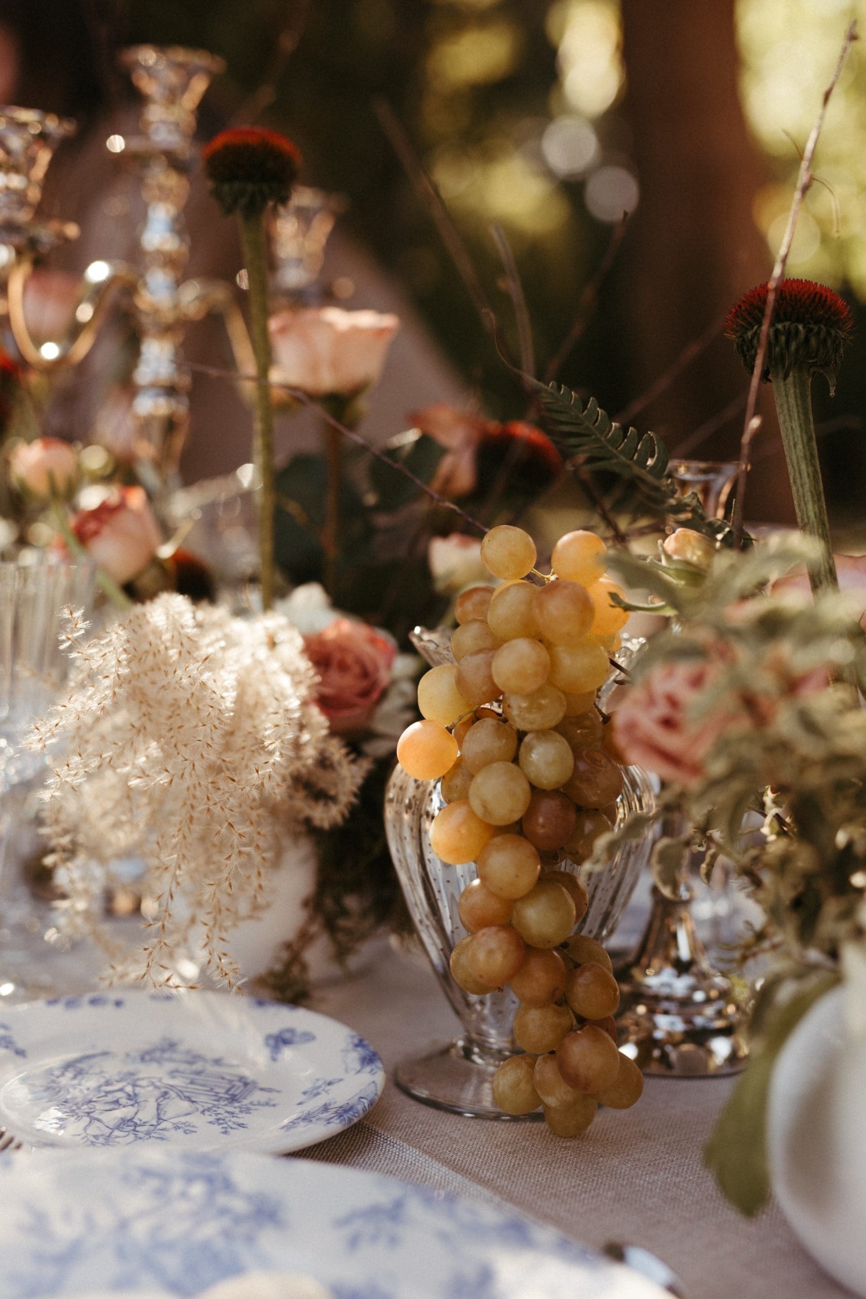 Mesa de bodas elegante con candelabros, uvas, velas y vajilla toile de jouy en Casa Santonja