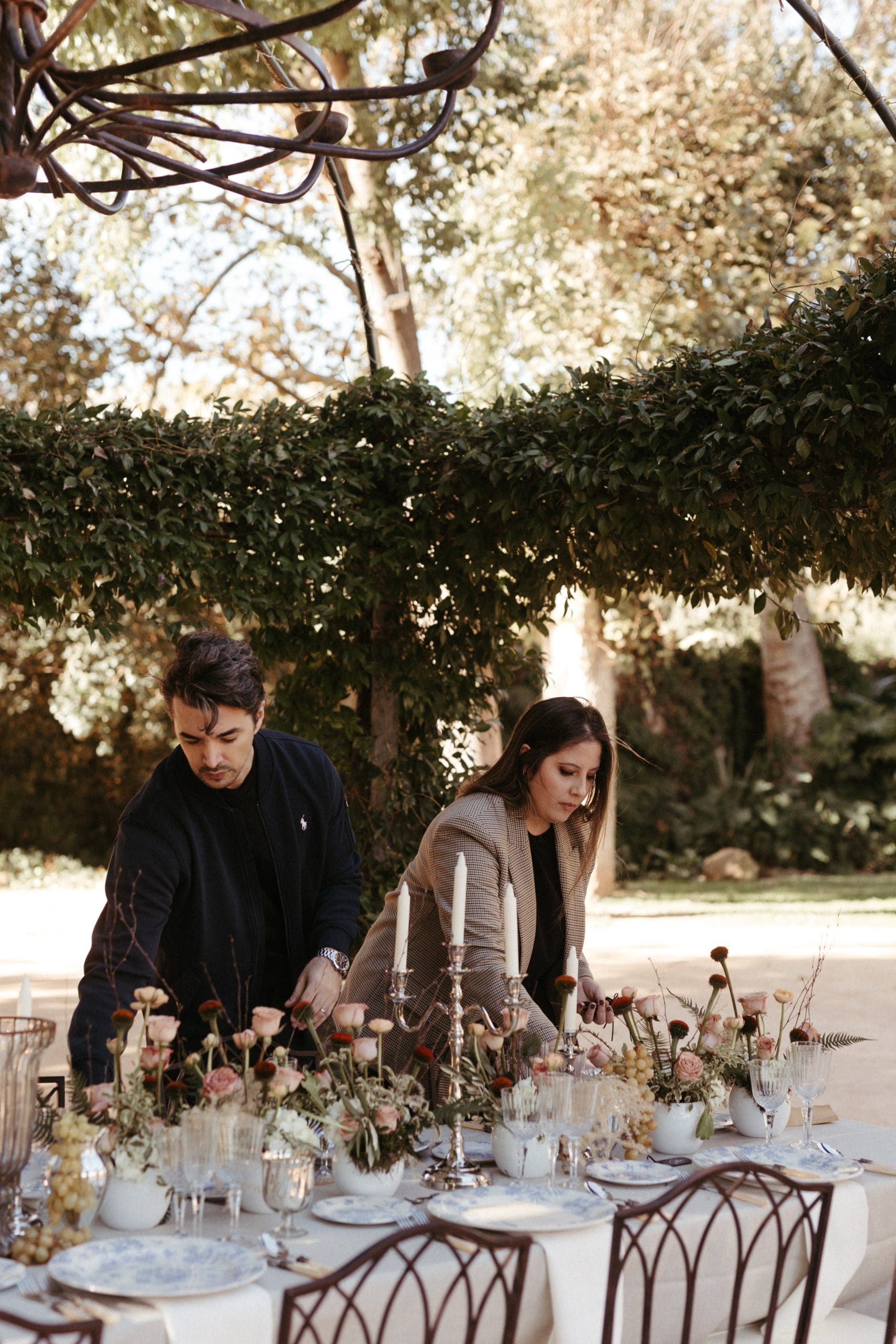 Wedding planners de Bouclé Weddings arreglando una mesa de bodas en un entorno natural.