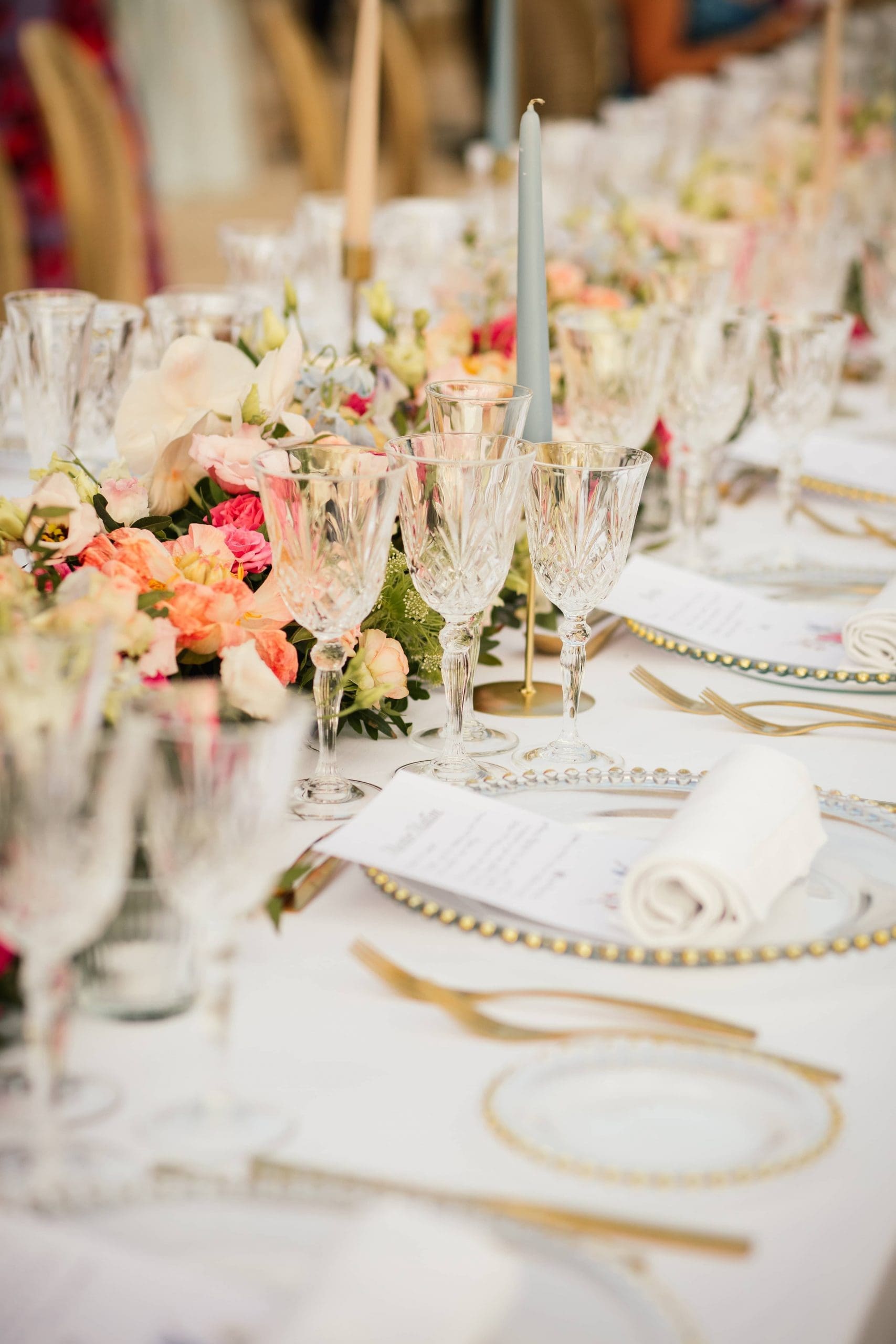 Mesa de bodas decorada por Bouclé Weddings en Mallorca con flores coloridas, cubertería dorada y cristalería brocada.