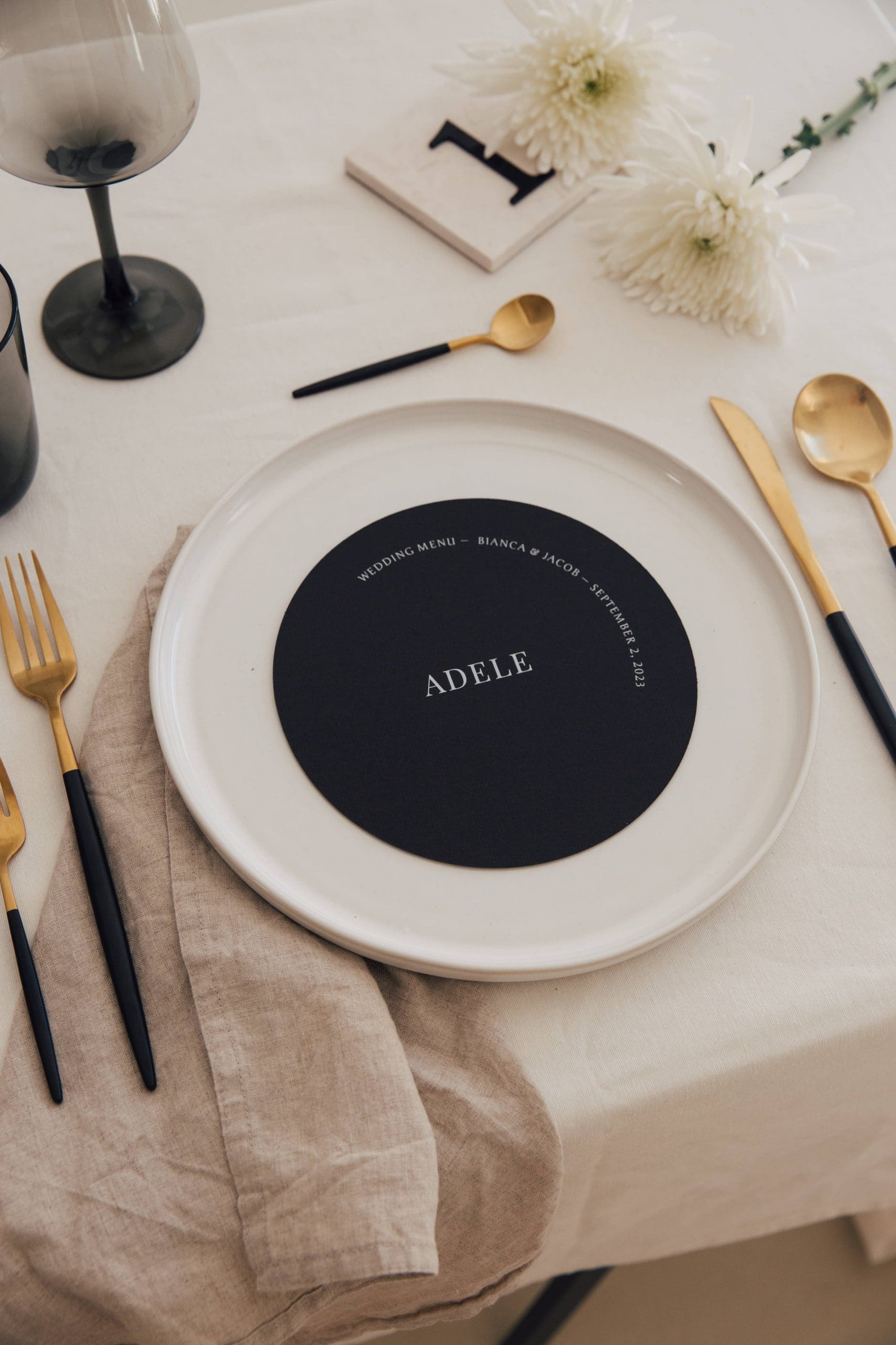 Minuta de boda redonda en color negro colocada sobre una mesa minimalista, destacando elegancia y simplicidad.