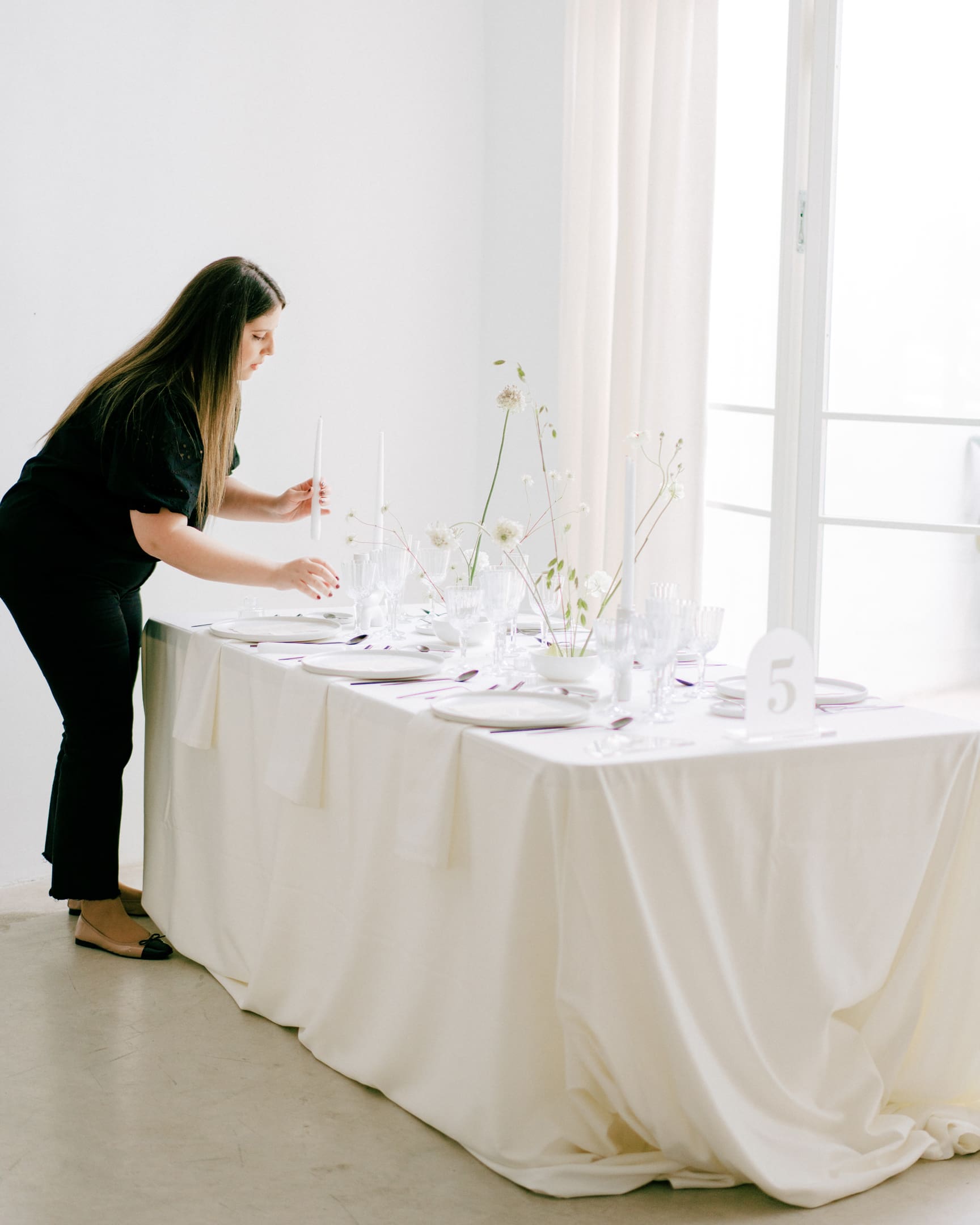 Estela de Bouclé Weddings diseñando una mesa de boda minimalista con decoración floral sencilla.