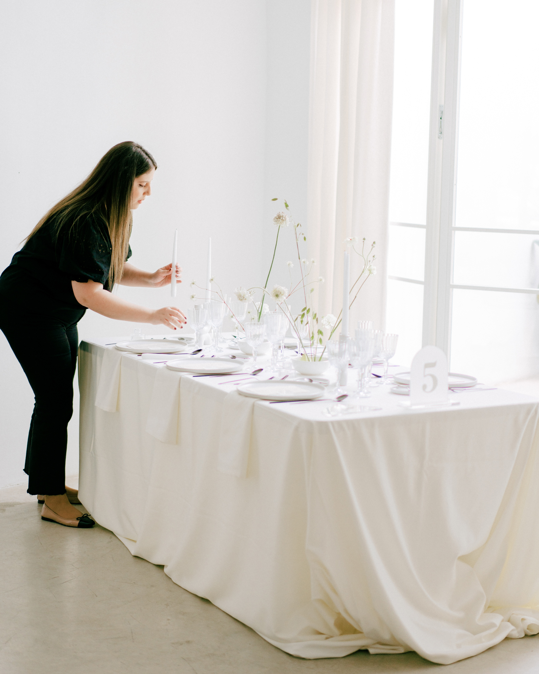 Estela de Bouclé Weddings diseñando una mesa de boda minimalista con decoración floral sencilla.