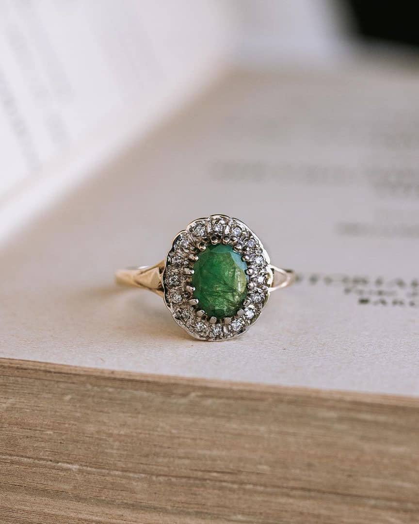 Anillo de compromiso vintage de Urbieta Antique sobre un libro antiguo