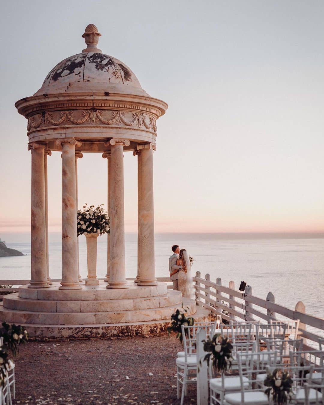 Románticas vistas del templete de mármol con una pareja disfrutando del atardecer en Finca Son Marroig, Mallorca.