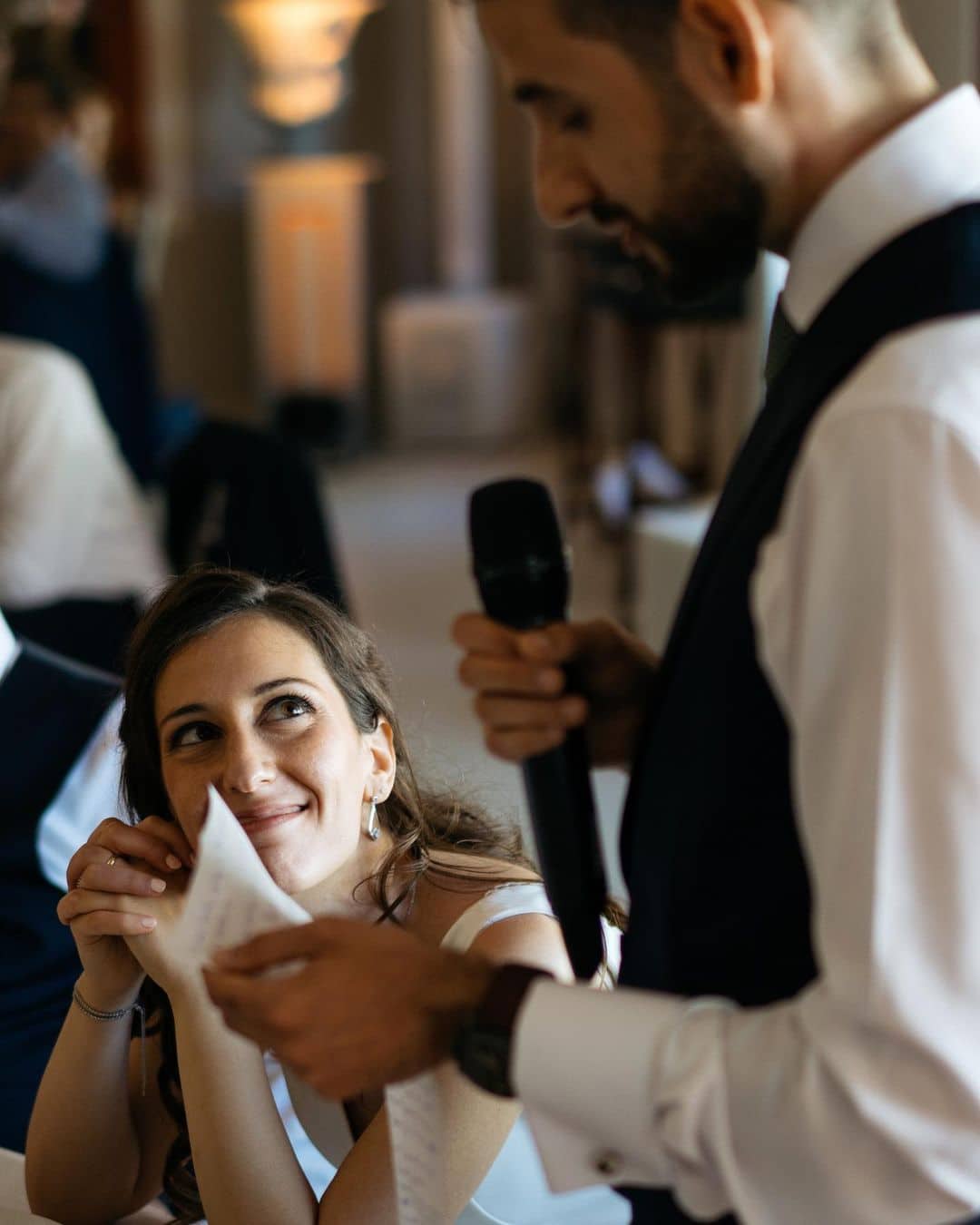 Novio emocionado leyendo sus votos matrimoniales, con la novia y los invitados observándole atentamente.