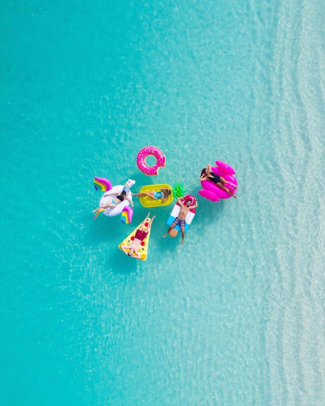 Personas disfrutando del mar en Turcas y Caicos con flotadores de colores durante su luna de miel