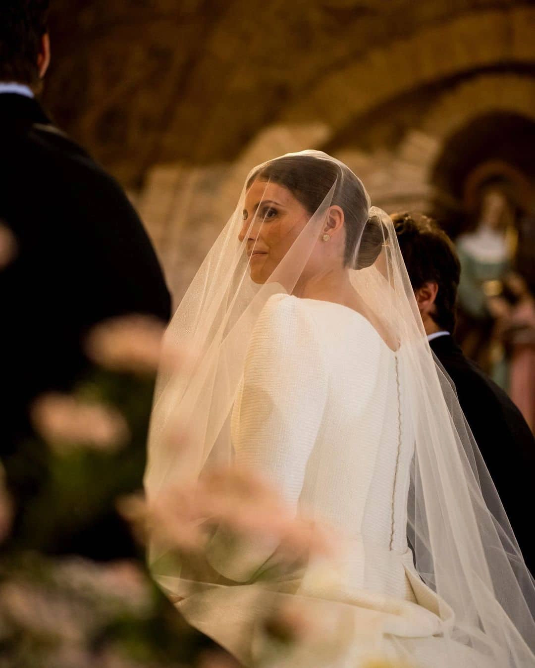 Novia con velo mirando a su novio con complicidad durante el rito de la velación - Bouclé Weddings
