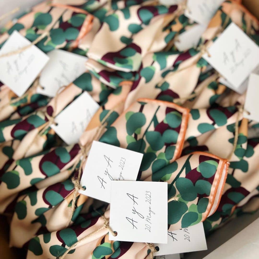 Regalos para invitados: Pañuelos personalizados de Tramo con motivos beige, marrones, lunares verdes y etiqueta con iniciales de los novios y fecha de la boda.