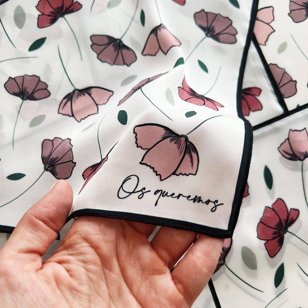 Regalos para invitados: Pañuelo personalizado de Tramo con estampado de flores y la frase 'Os queremos'.