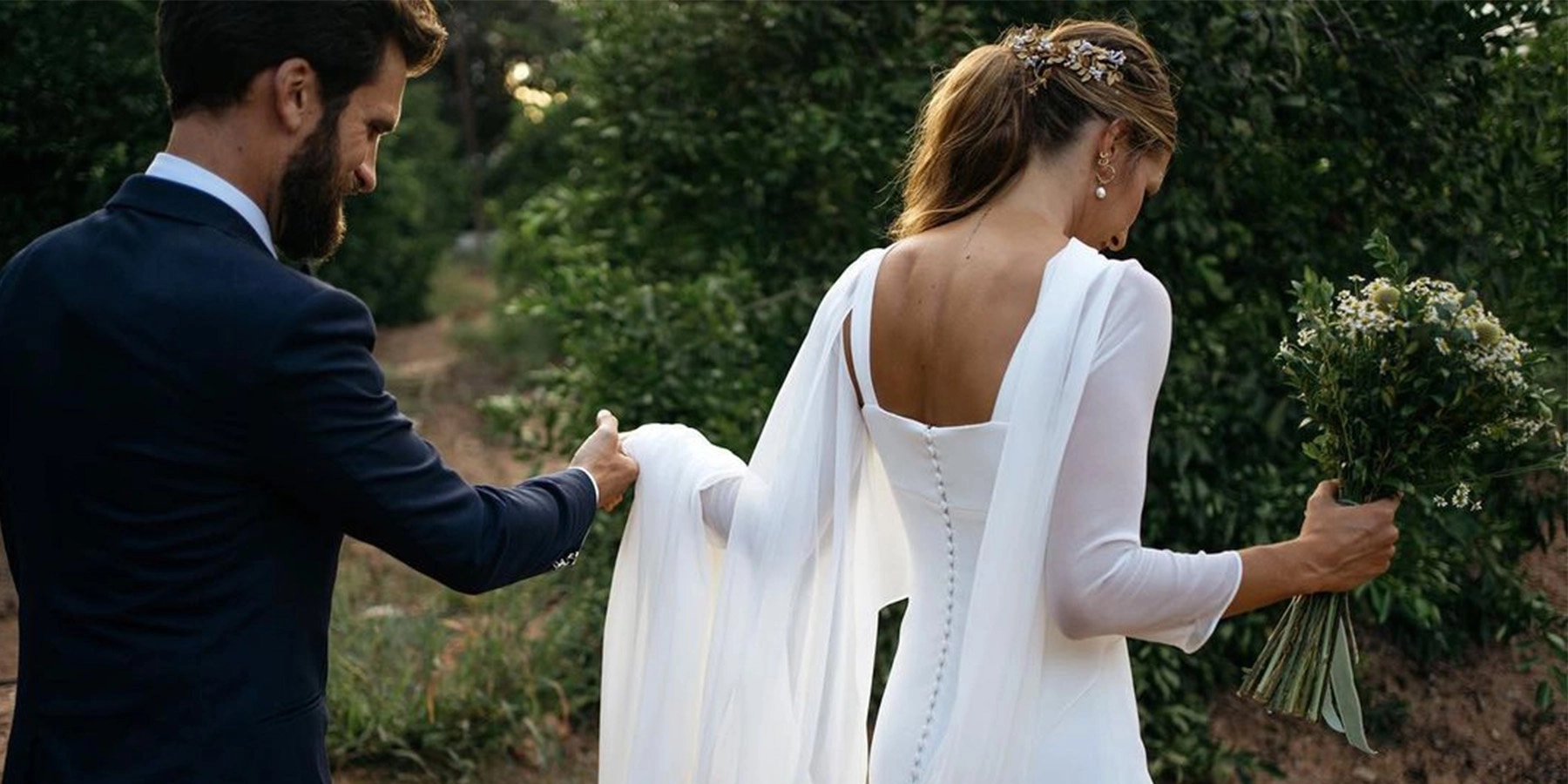 Novios agarrados de la mano, caminando juntos en un camino de amor y compromiso tras sus votos de boda.