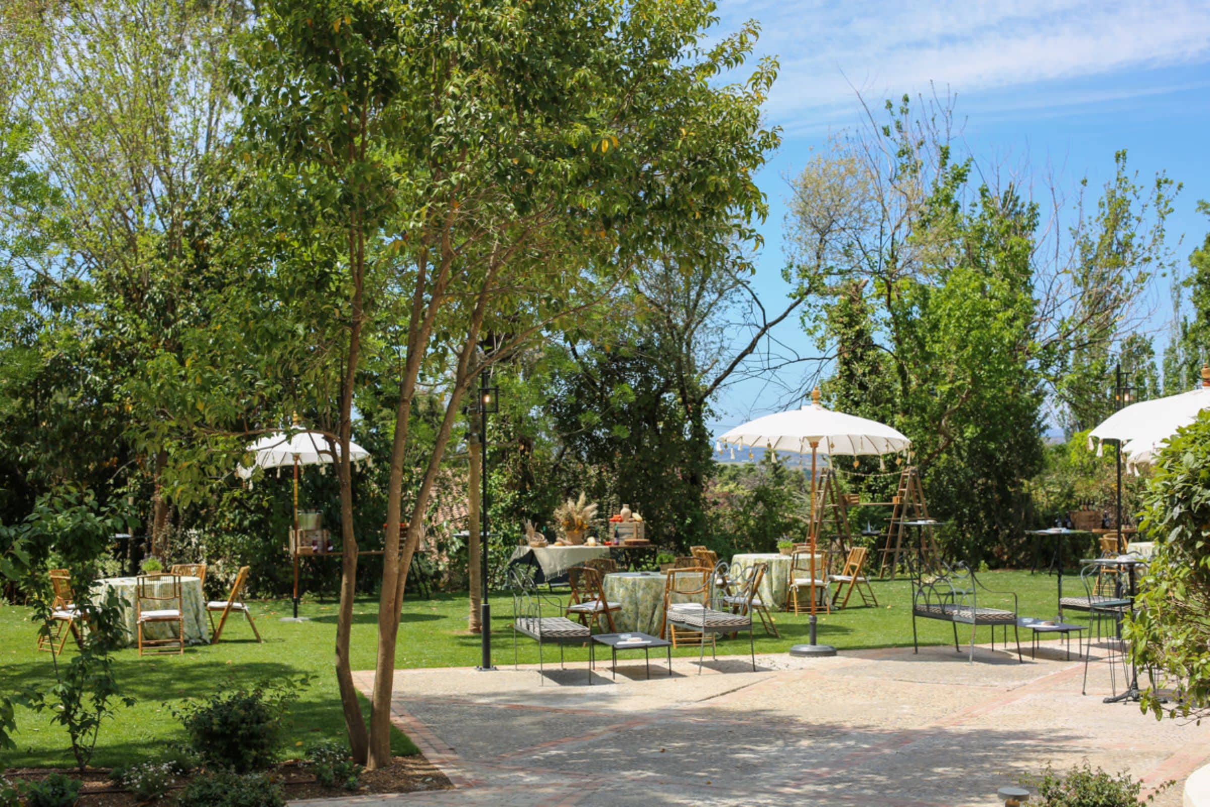 Jardín exterior de Cortijo de Mónico con mesa de cóctel preparada para recepción de boda