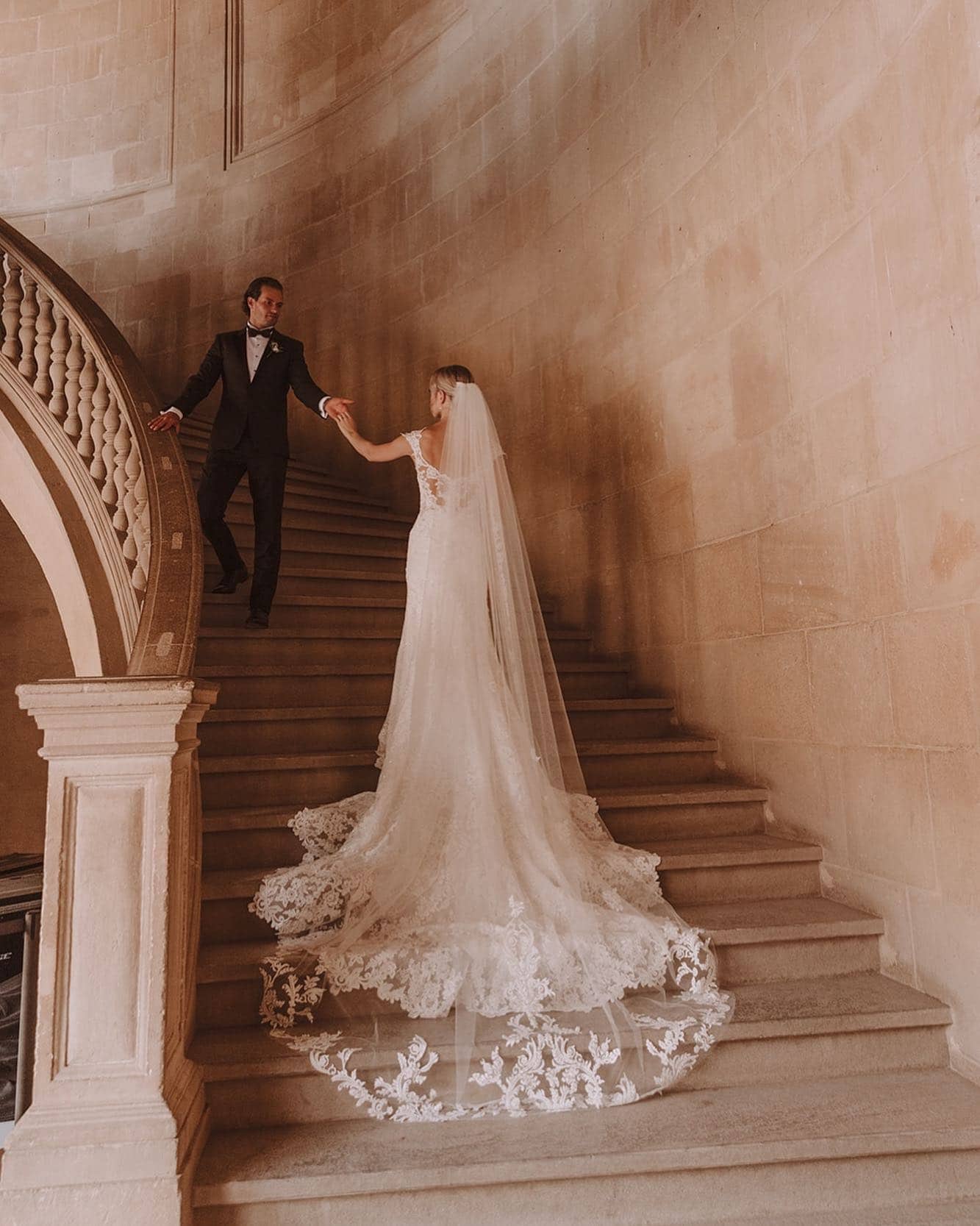 Pareja de novios subiendo una escalera juntos, enfrentando nervios antes de la boda