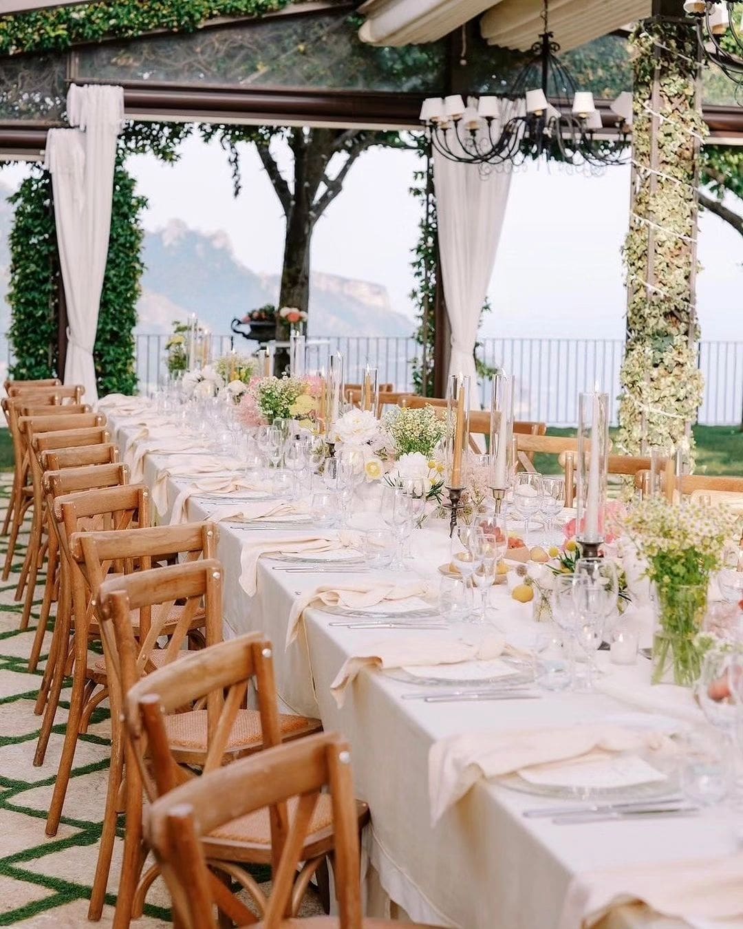 Mesa de bodas elegantemente decorada en Villa Eva, Costa Amalfitana, con vista panorámica al mar y rodeada de vegetación exuberante