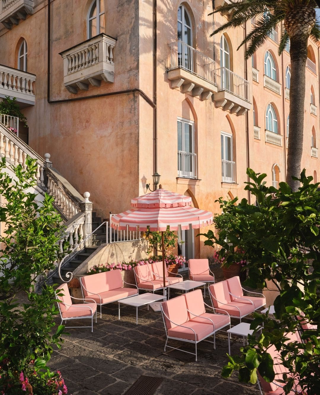 Zona chill out con sillones rosas y sombrilla rosa en Palazzo Avino.