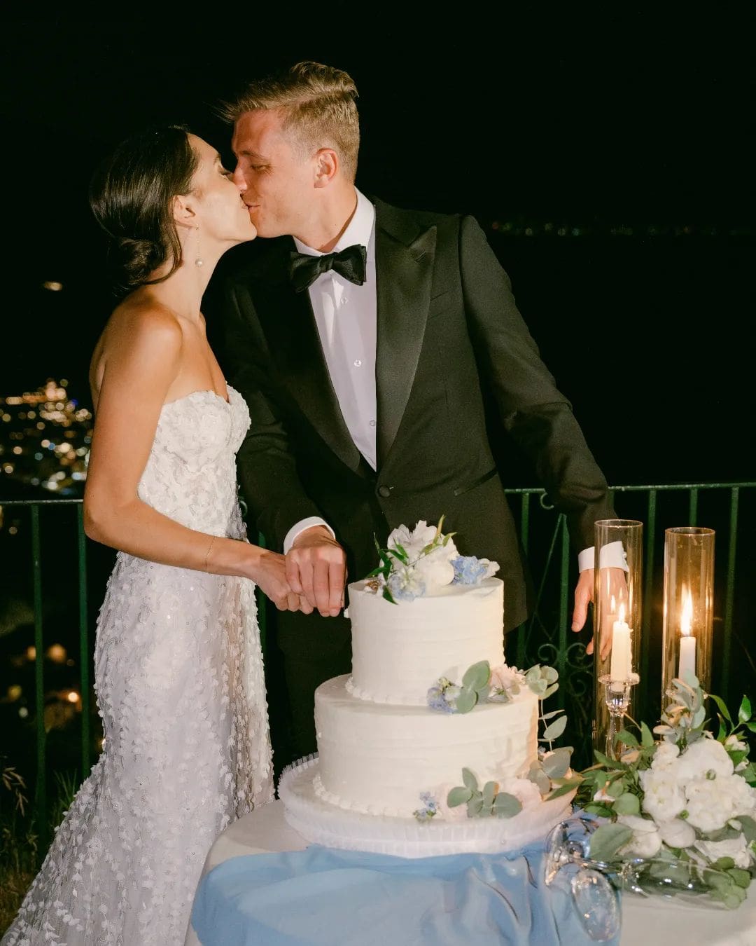 Pareja besándose junto a una tarta de bodas en el Palazzo Confalone en Ravello.