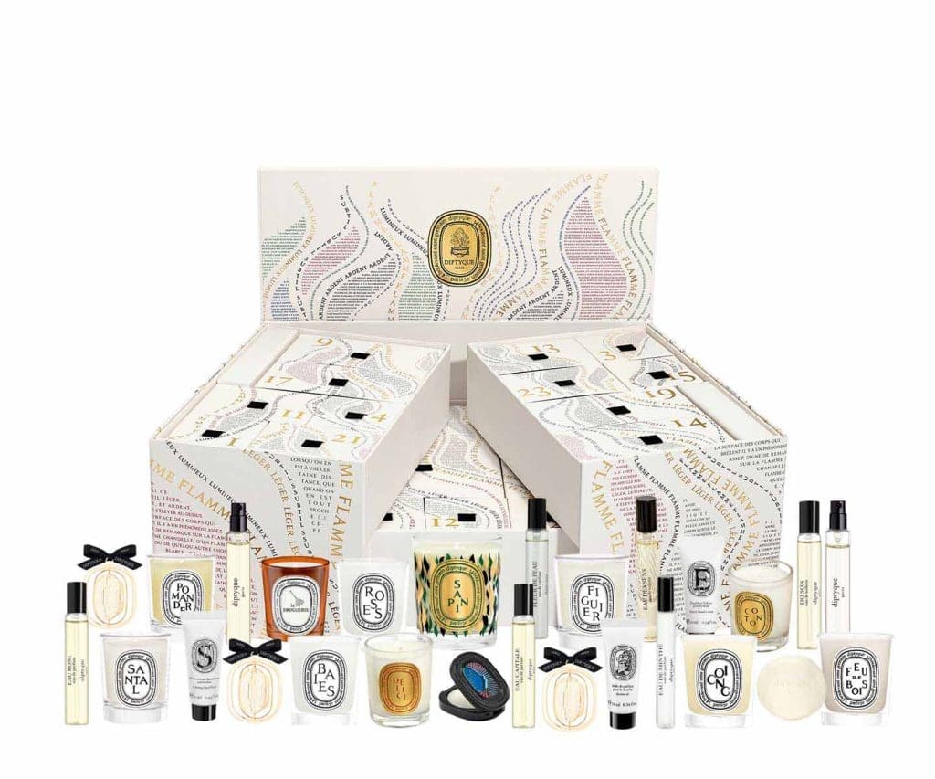 Calendario de Adviento de Diptyque con 25 tesoros perfumados, diseño artístico de caligramas y enfoque en sostenibilidad y reutilización.