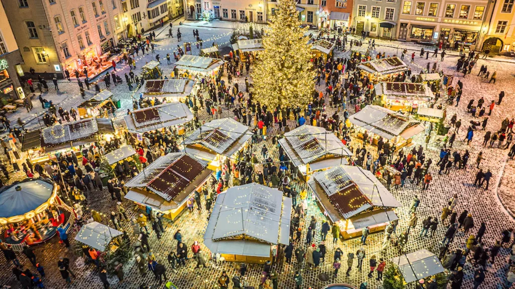 Mercado de Navidad en la Plaza del Ayuntamiento de Tallin con artesanías locales, Santa Claus y un árbol navideño impresionante.