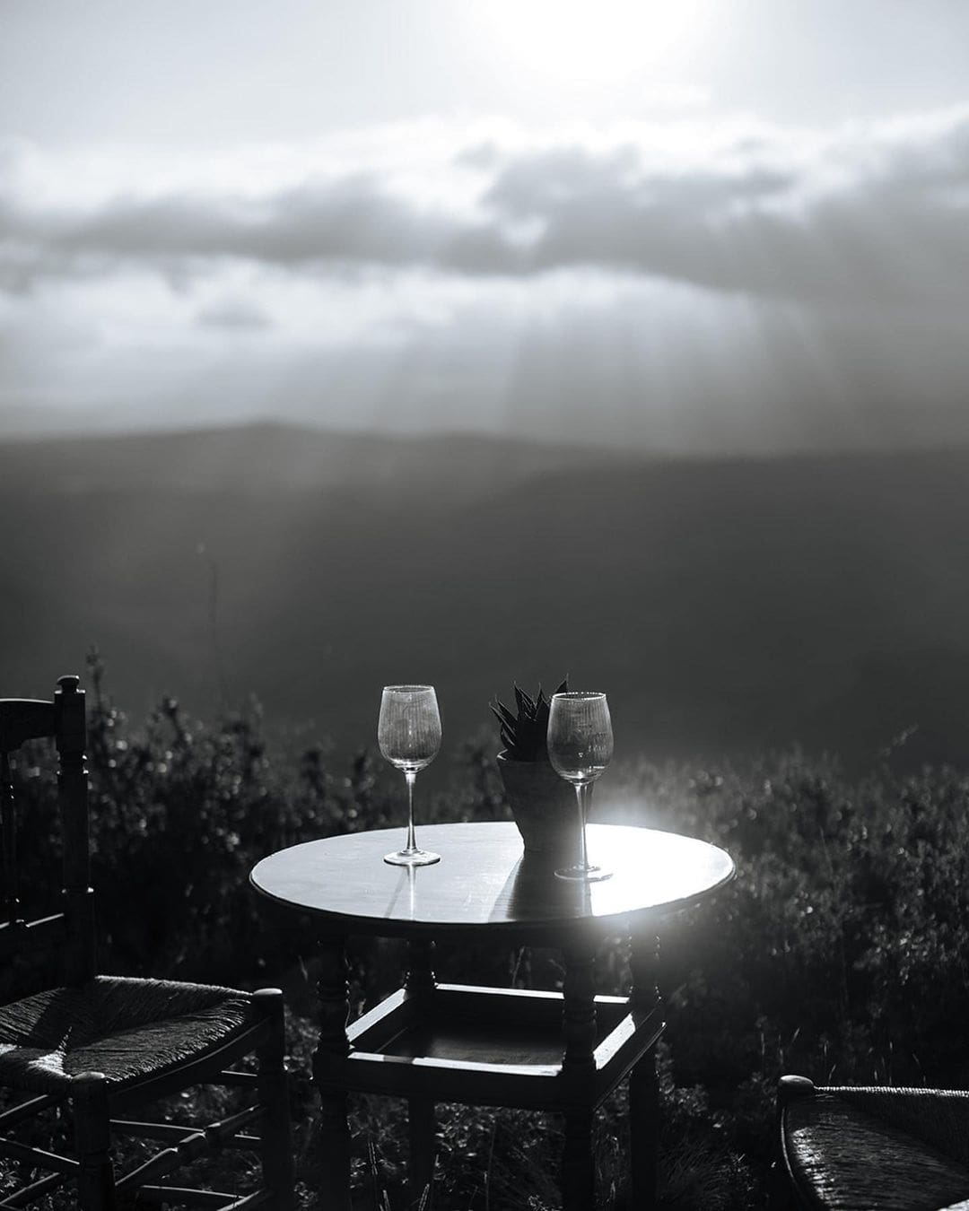 Dos copas de vino sobre una mesa en la terraza, esperando una noche romántica de San Valentín.