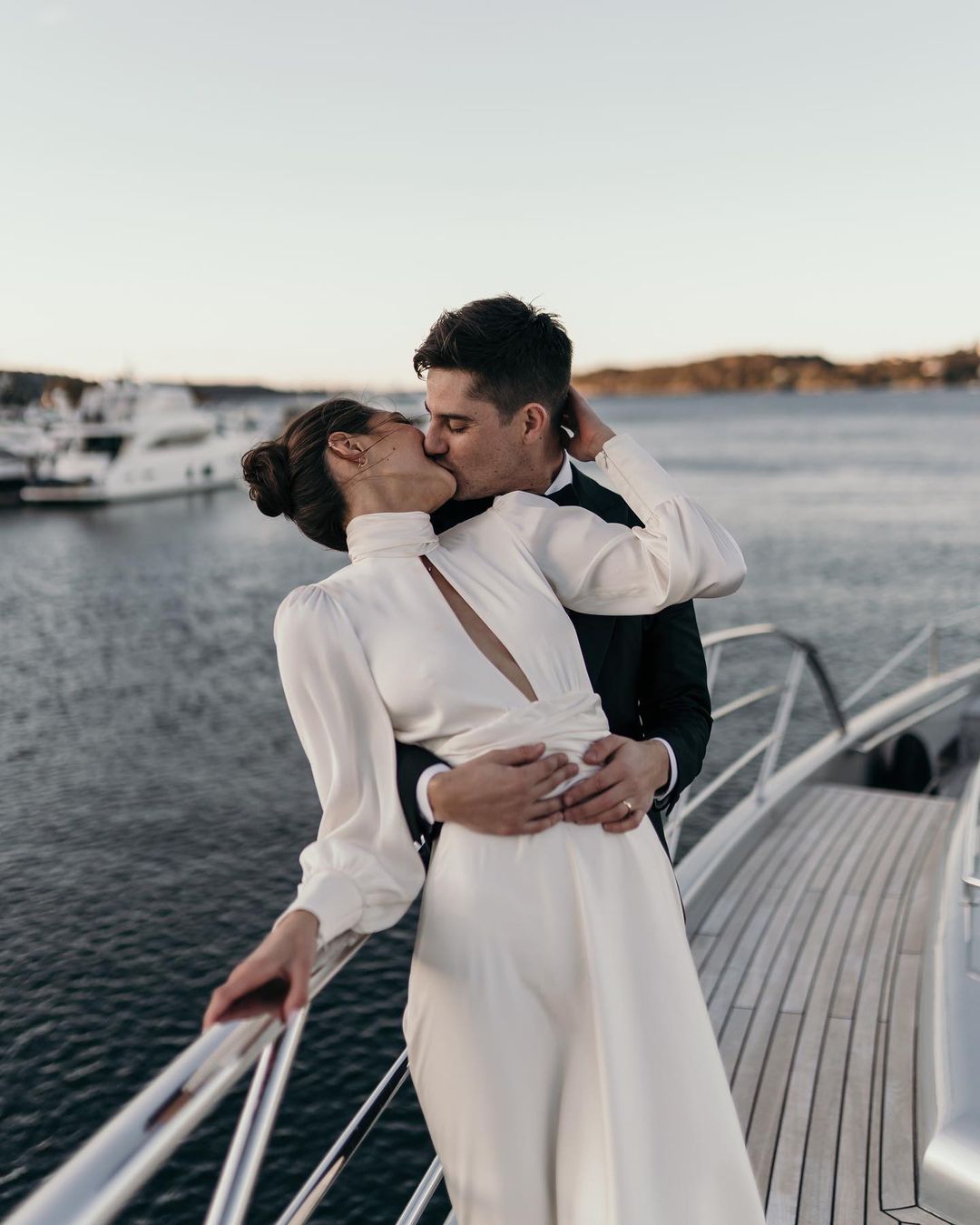 Novios compartiendo un beso en un barco, ejemplificando la unión de amor y tecnología en la organización de bodas digital.