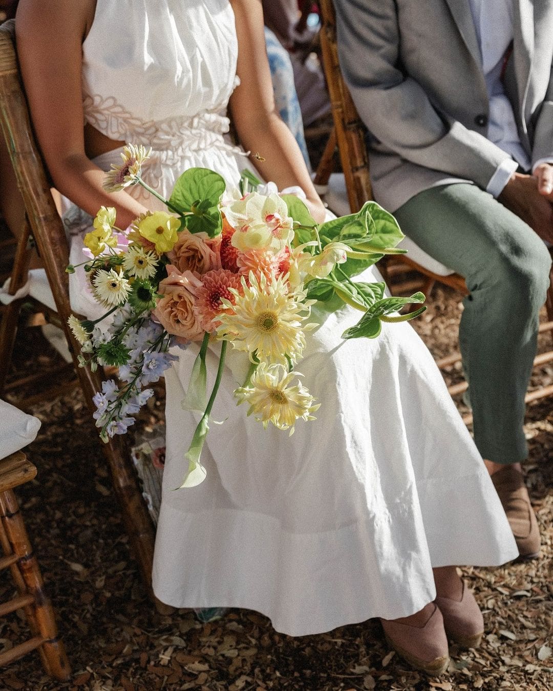 Novia sostiene un ramo desestructurado con margaritas blancas y flores de colores.
