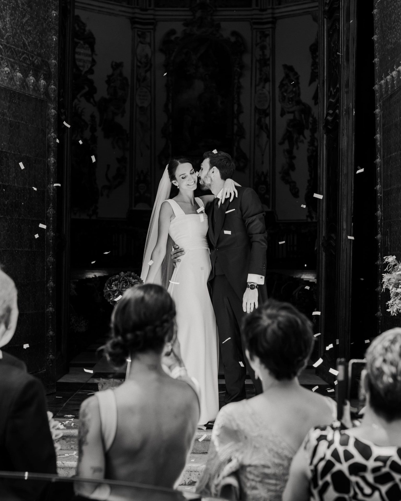 Novios besándose en la salida de la iglesia, mostrando cuánto cuesta una boda según el lugar y los servicios incluidos.